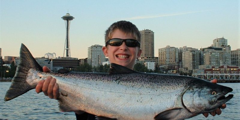 Seattle Salmon Fishing Salmon Held By Boy In Front Of Seattle Waterfront